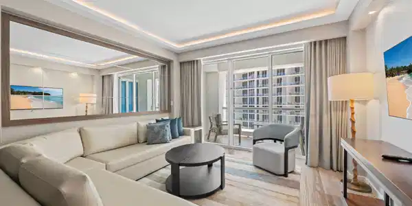 Image 2: Expansive living space featuring a full-wall mirro