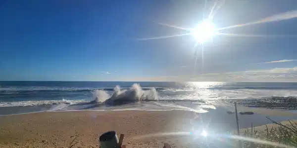 Image 3: Expansive sandy beach with breaking waves under a