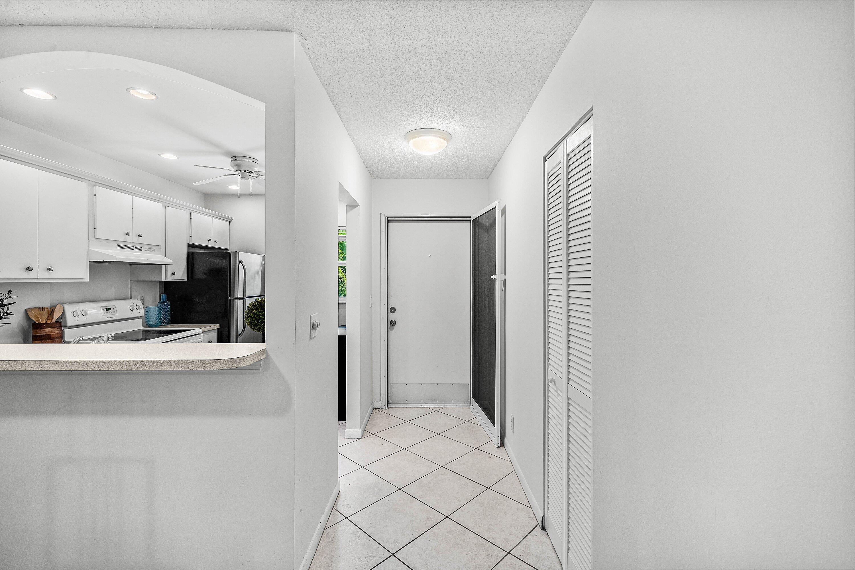 Image 3: White kitchen cabinetry with black appliances, arc