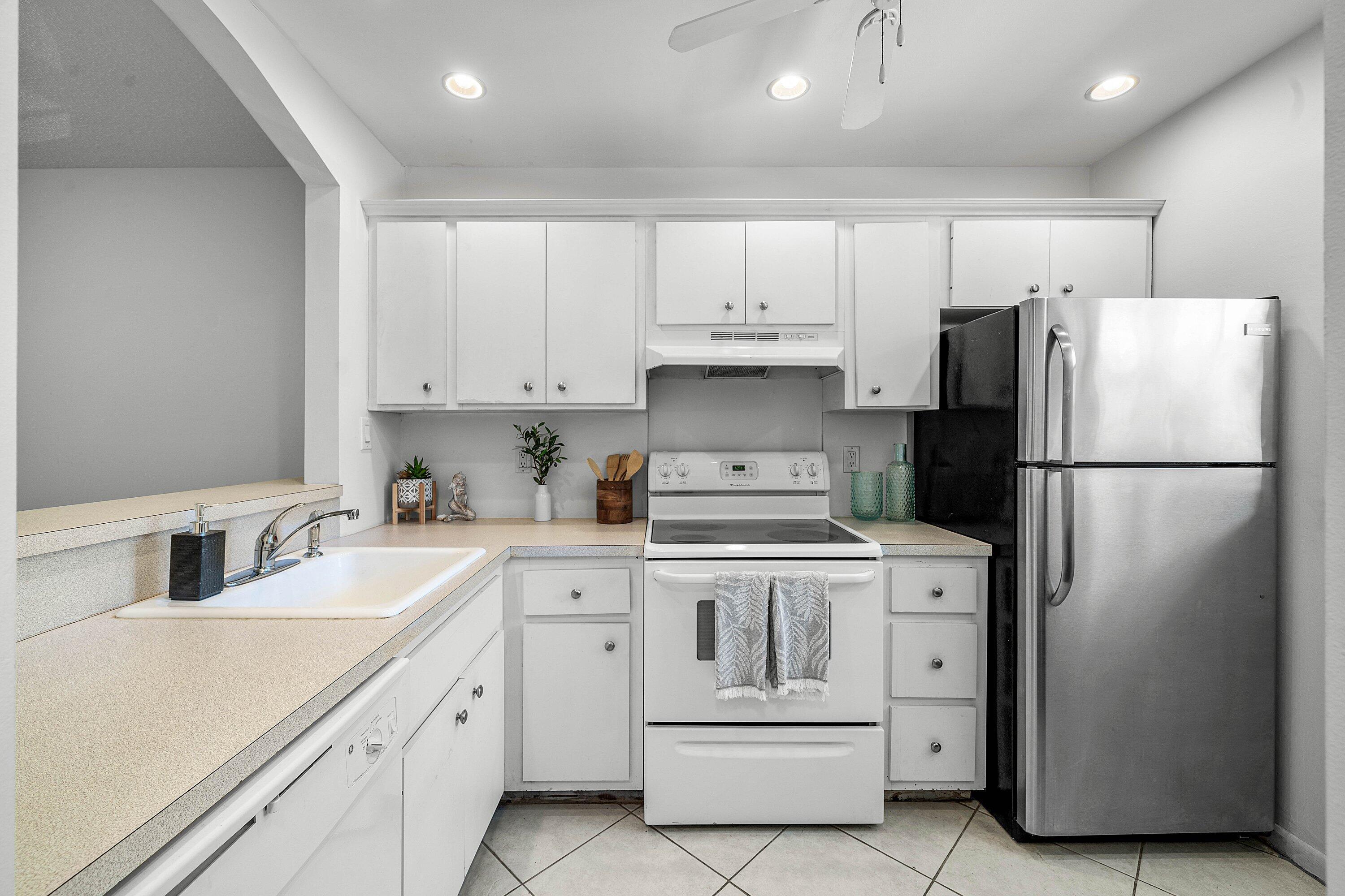 Image 4: White cabinetry, light-toned countertops, white ti