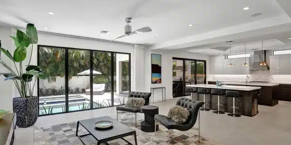 Image 2: Open living room kitchen with pool views.