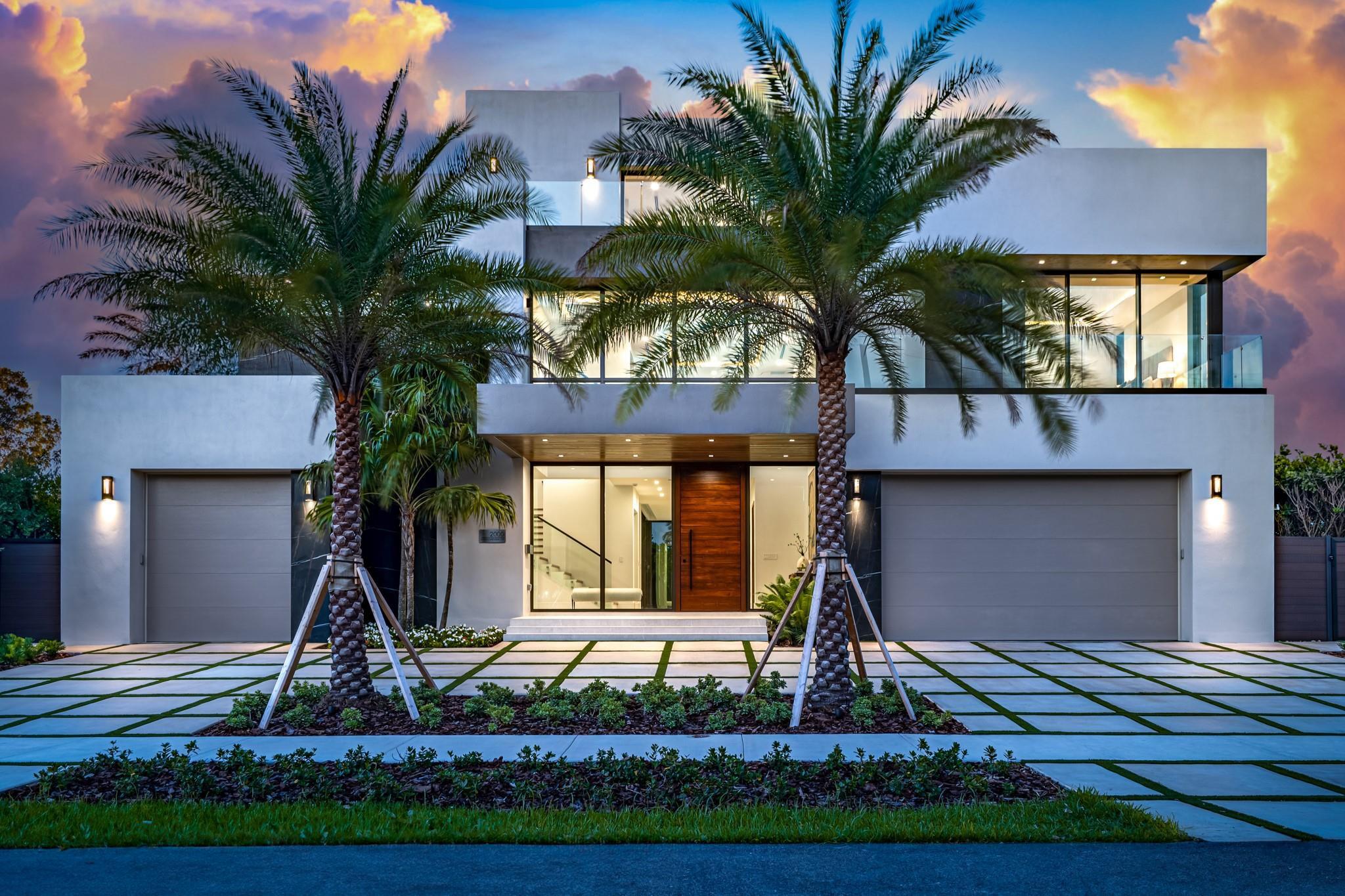 Image 1: A striking modern fa&ccedil;ade framed by towering palms