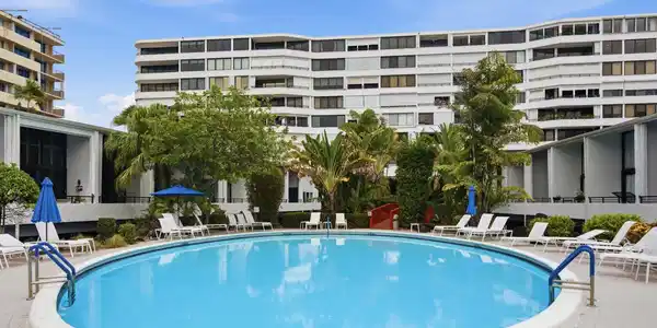 Image 2: Circular swimming pool with a white coping, surrou