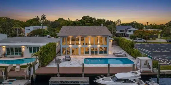 Image 2: Back of home at twilight with vast pool and waterf