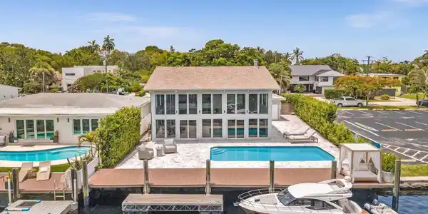 Image 3: Back of home with vast pool and waterfront access.