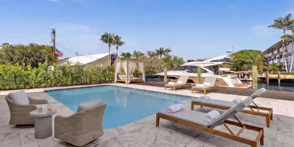 Image 4: Back of home with lounge chaises and patio furnitu