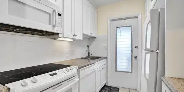 Image 3: Kitchen featuring white cabinetry with silver hard