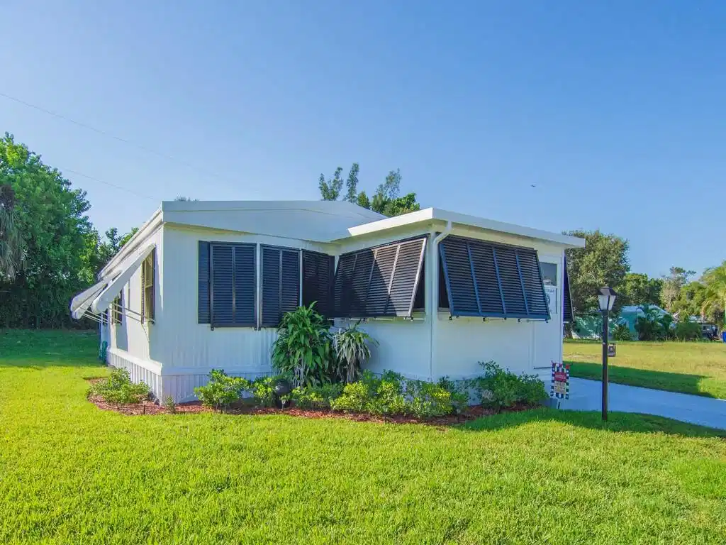 Image 1: White horizontal siding, black louvered shutters,