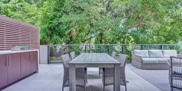 Image 3: Expansive outdoor terrace featuring light-toned la