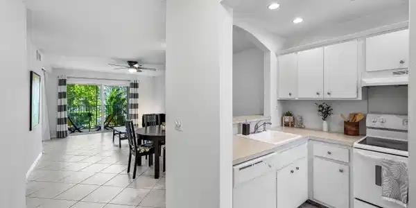 Image 3: White cabinetry in the kitchen with a built-in dis