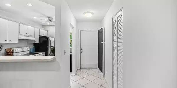 Image 4: White kitchen cabinetry with black appliances, arc