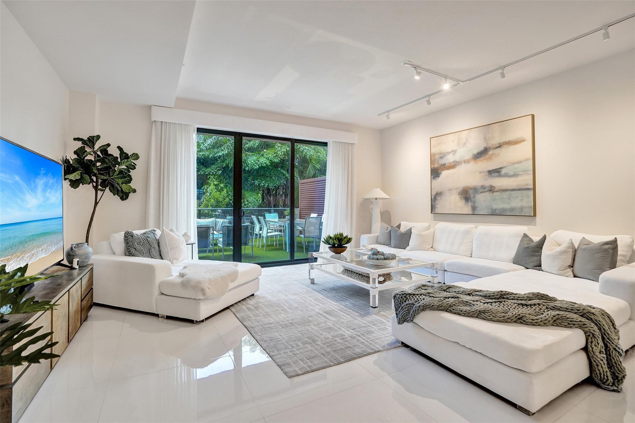 Image 1: large living space with lush green views