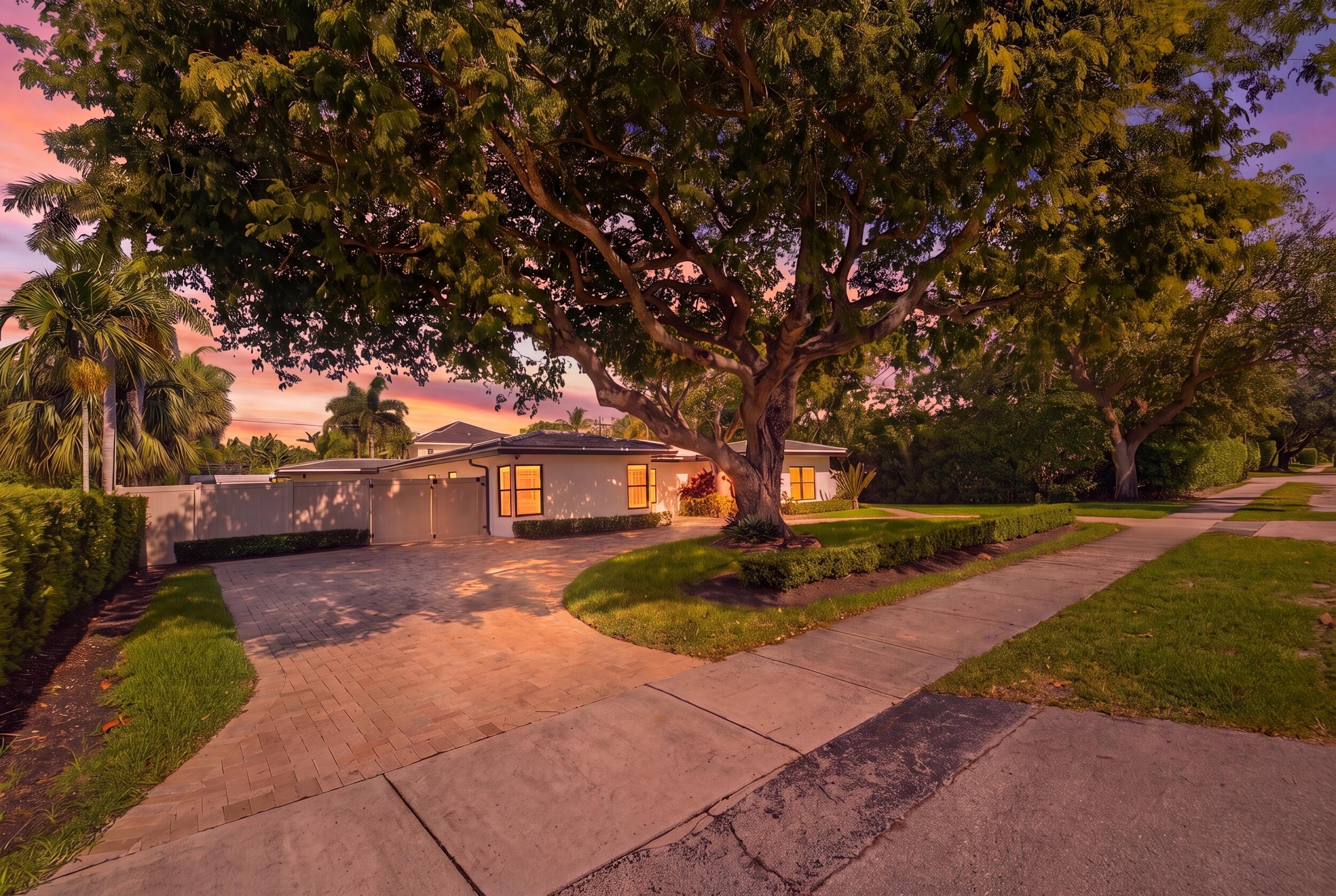Image 1: Expansive paver driveway with surrounding lush lan