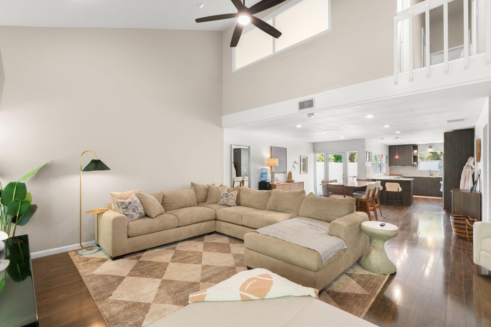 Image 3: Living room with vaulted ceilings, large windows,
