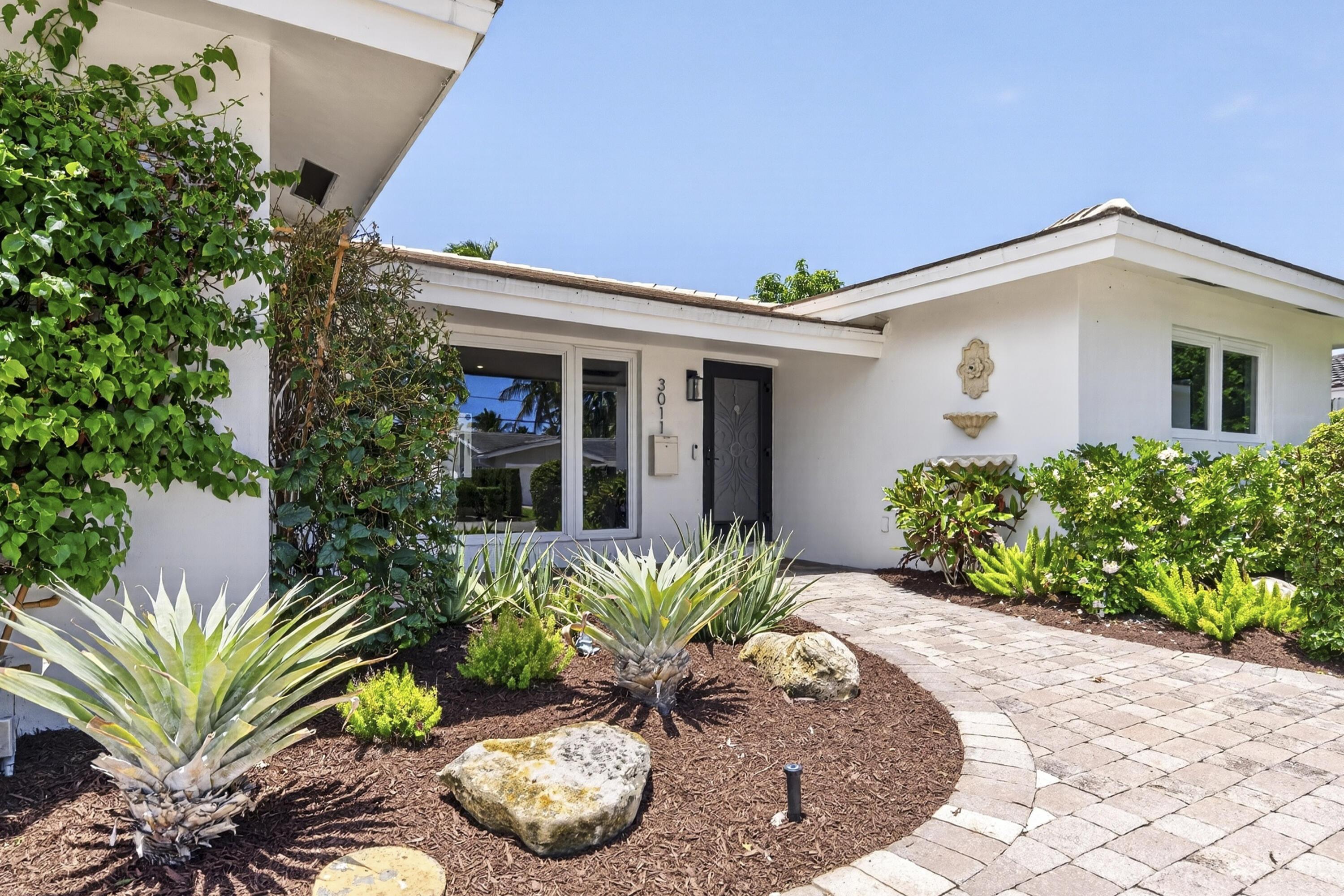 Image 4: White stucco exterior with a dark entry door, fram