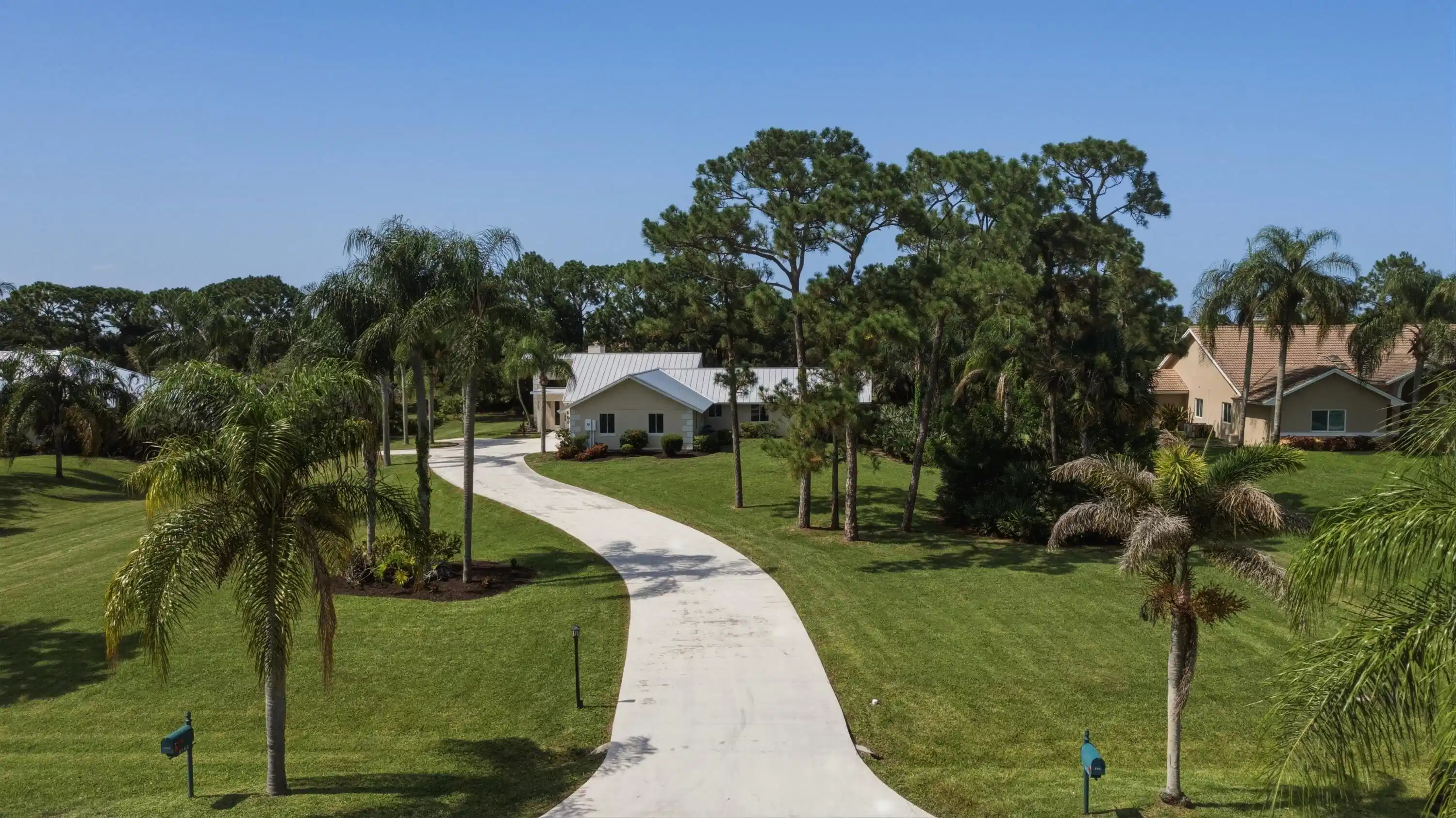Image 1: Winding concrete driveway leading to a residence f