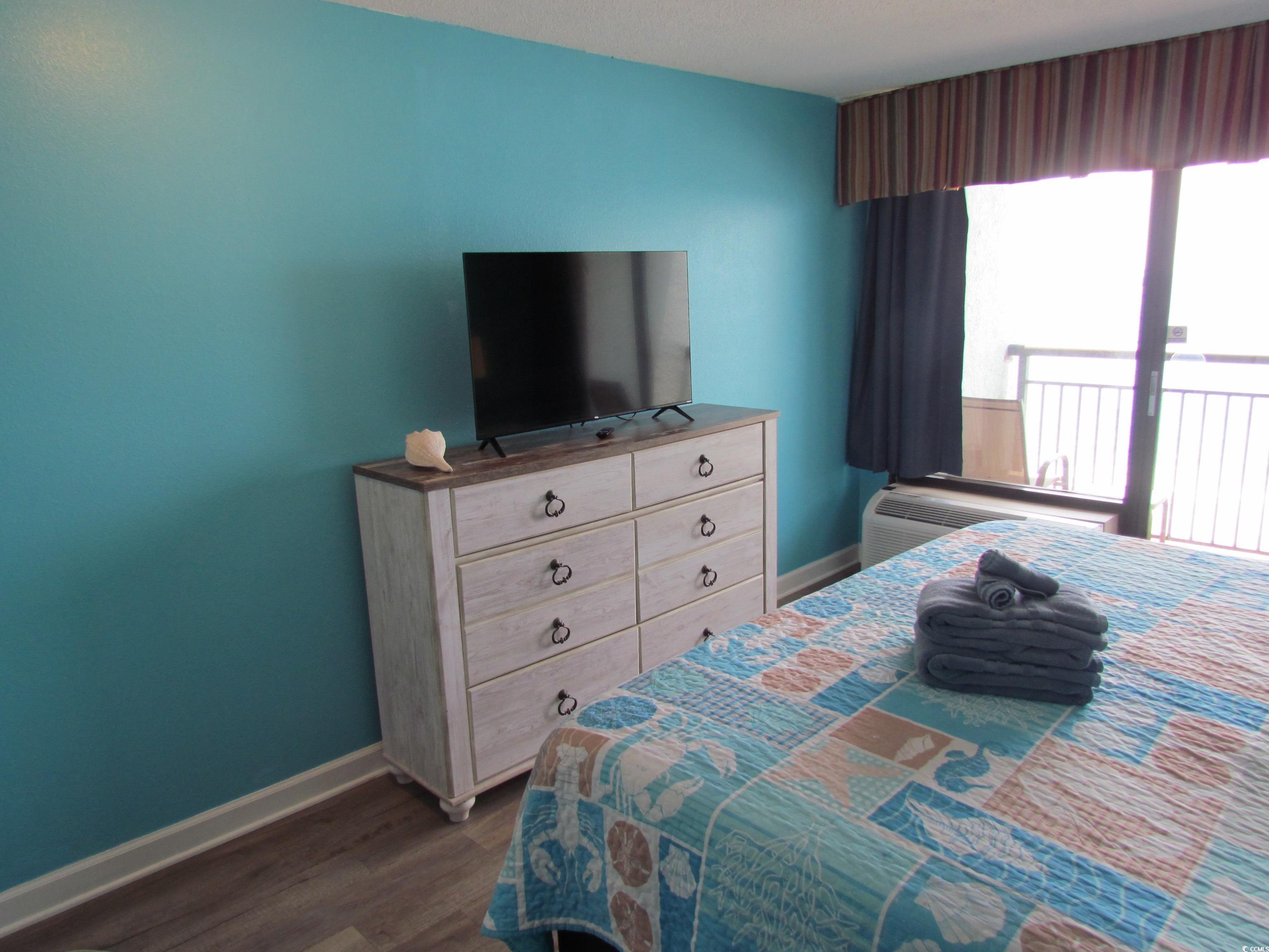 Image 3: Bedroom with baseboards and dark wood-style floori Image 3: Bedroom with baseboards and dark wood-style floori