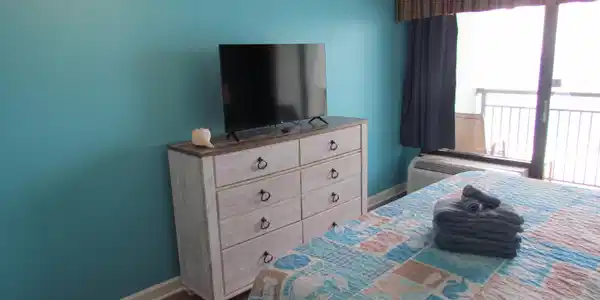 Image 3: Bedroom with baseboards and dark wood-style floori