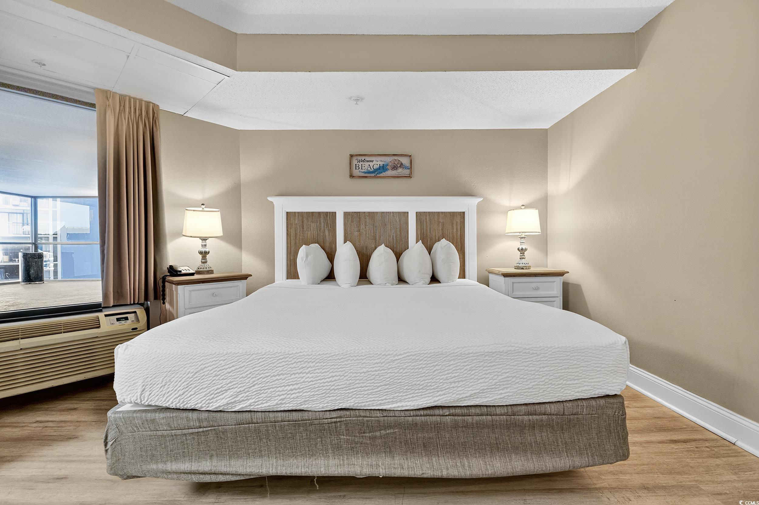 Image 4: Bedroom with light wood-type flooring and an AC wa Image 4: Bedroom with light wood-type flooring and an AC wa