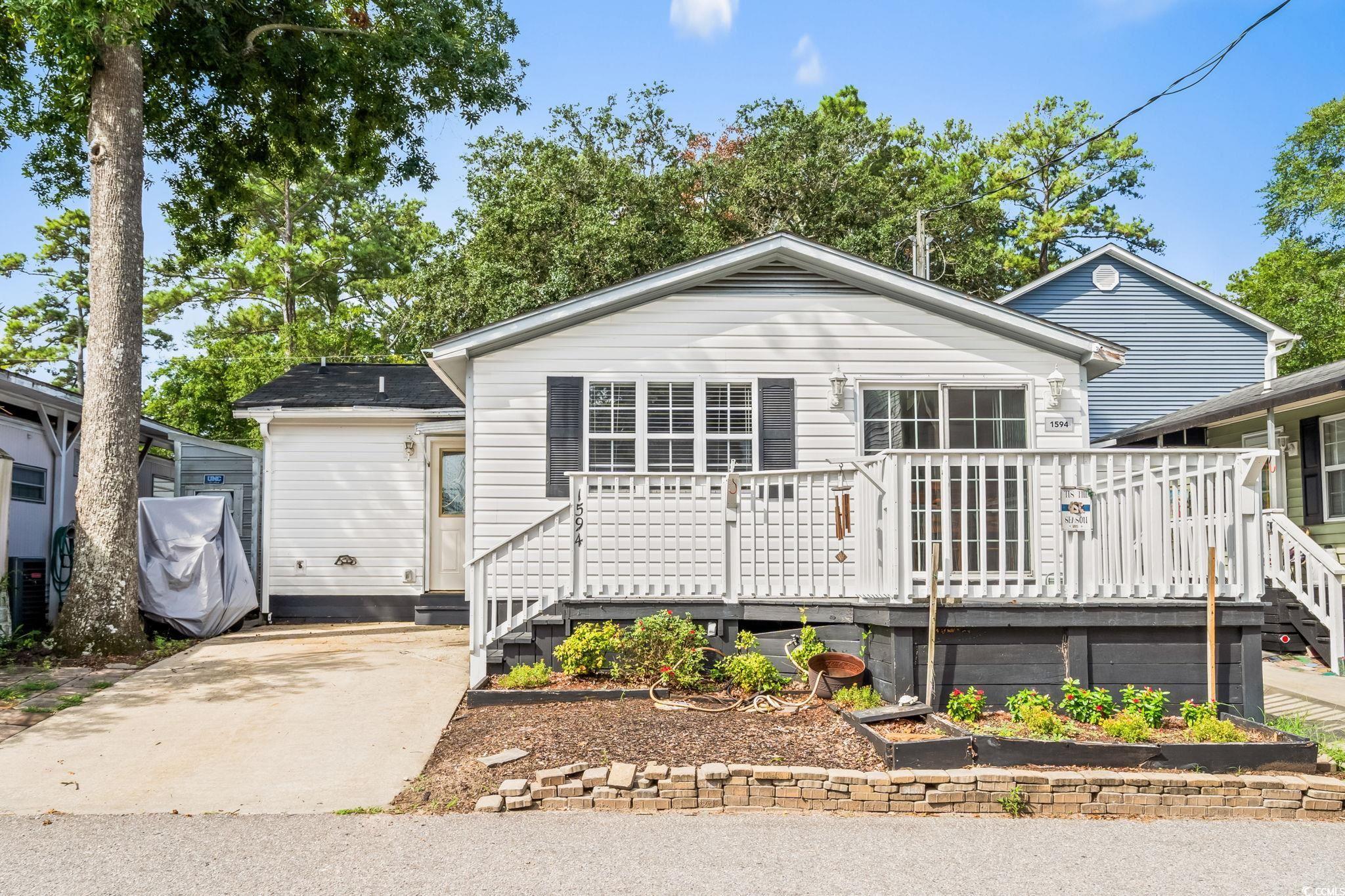 Image 2: View of front facade featuring a wooden deck Image 2: View of front facade featuring a wooden deck
