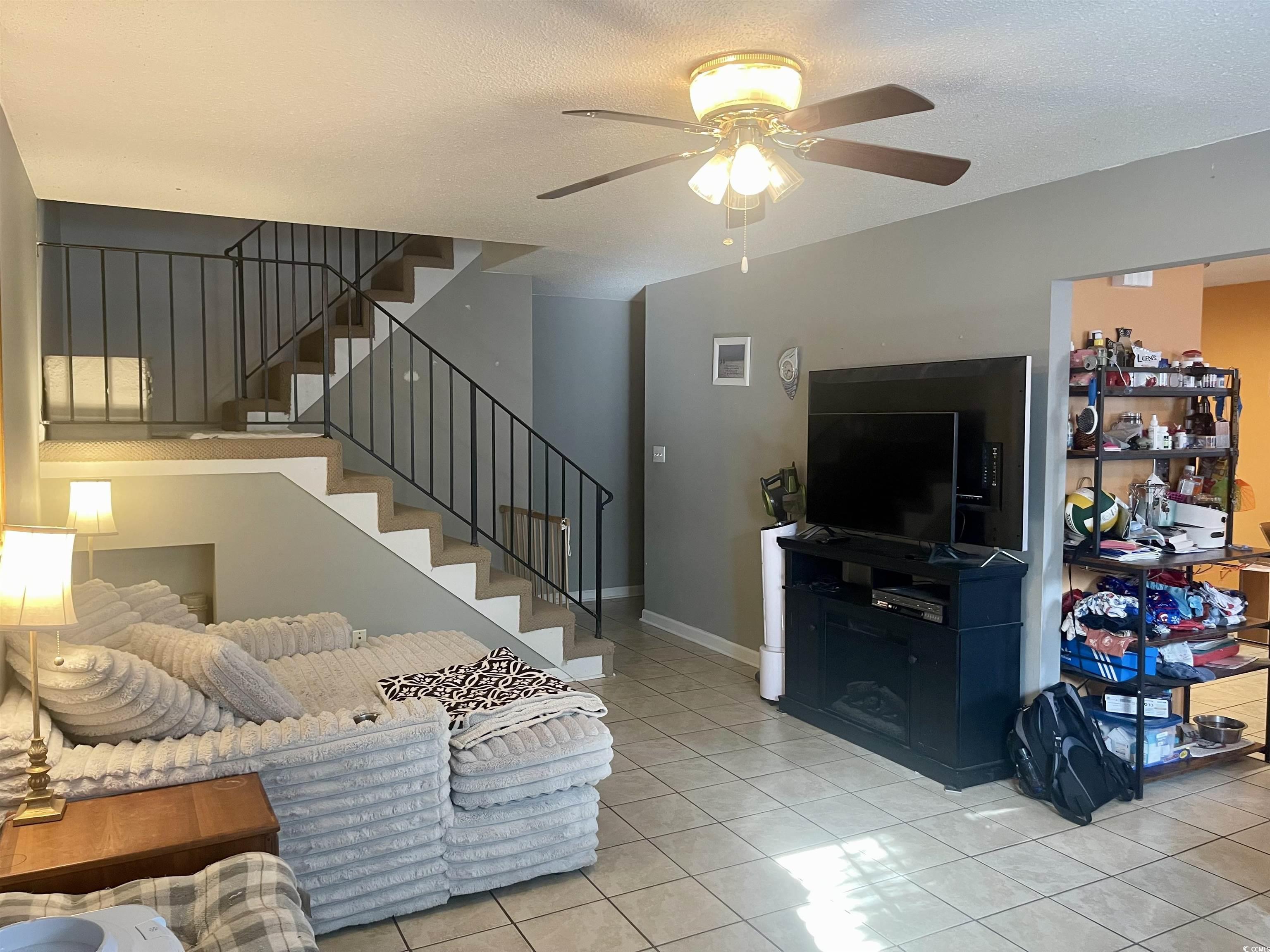 Image 2: Living area featuring stairs, light tile patterned