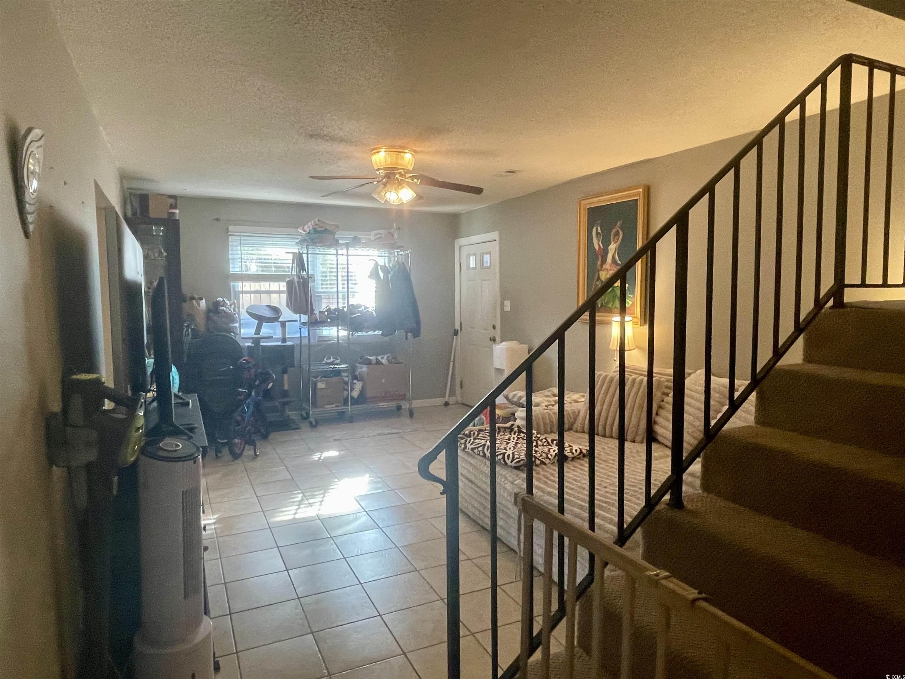 Image 3: Foyer entrance with a textured ceiling, stairs, li