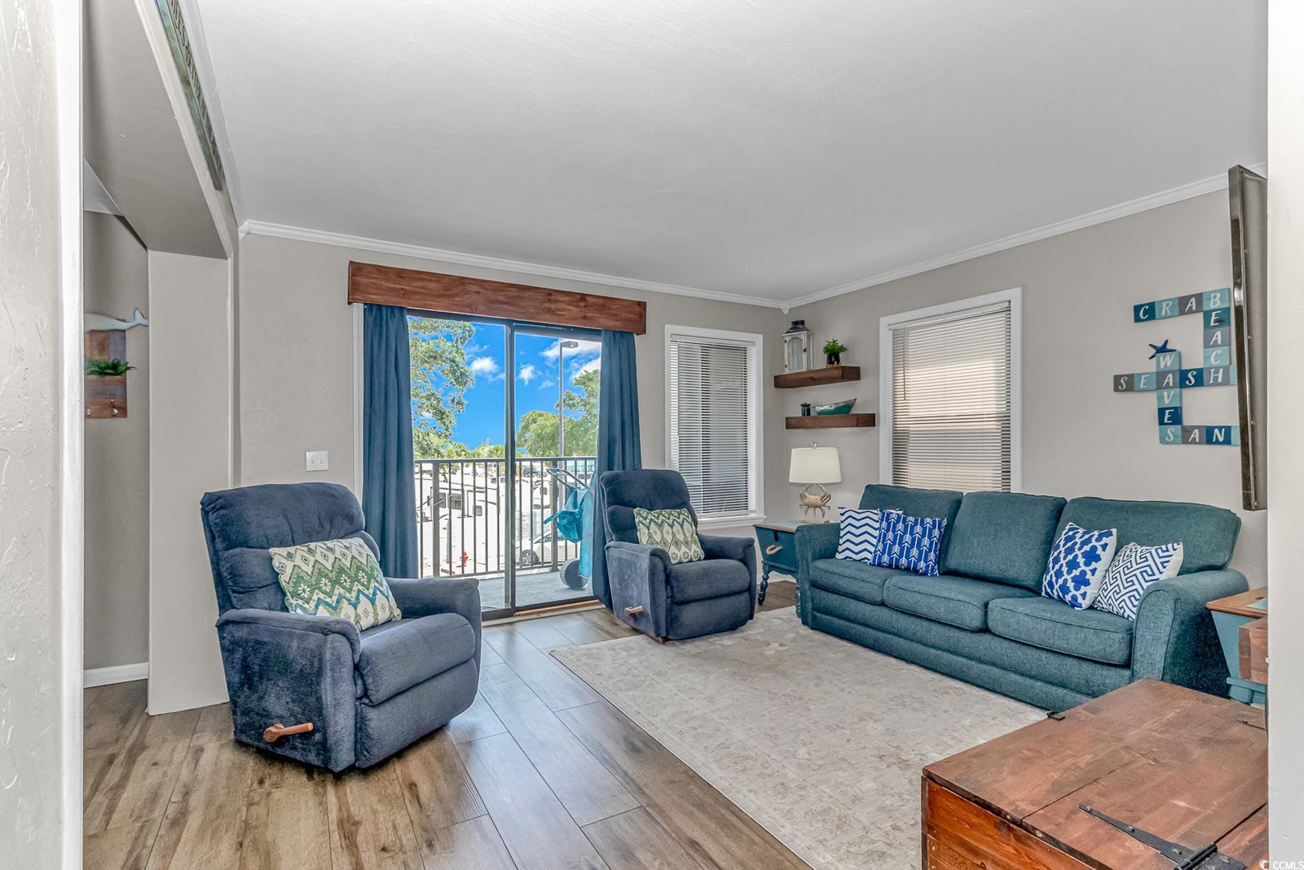 Image 3: Living area with wood finished floors and crown mo