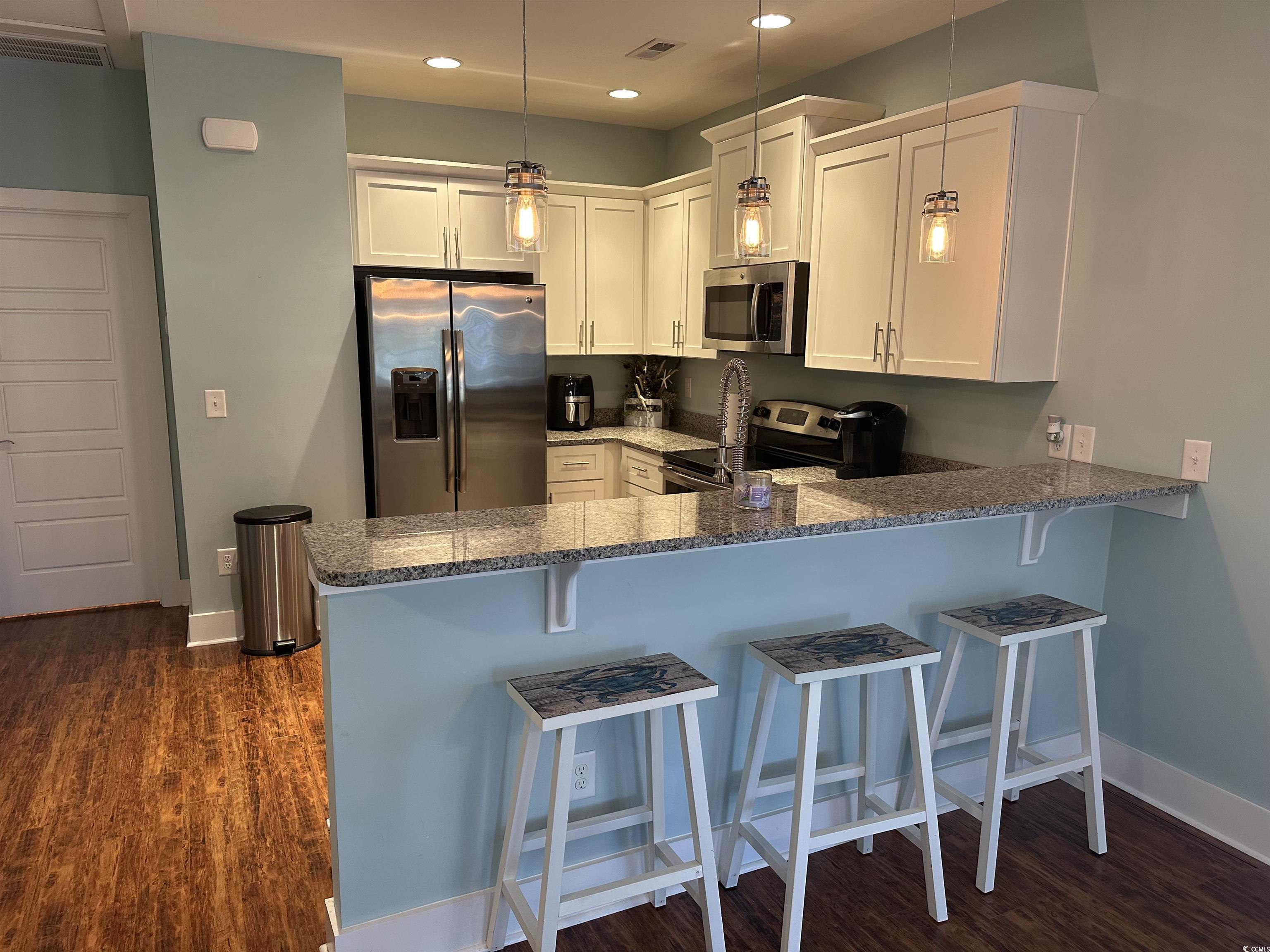 Image 3: Kitchen featuring a kitchen breakfast bar, stainle Image 3: Kitchen featuring a kitchen breakfast bar, stainle