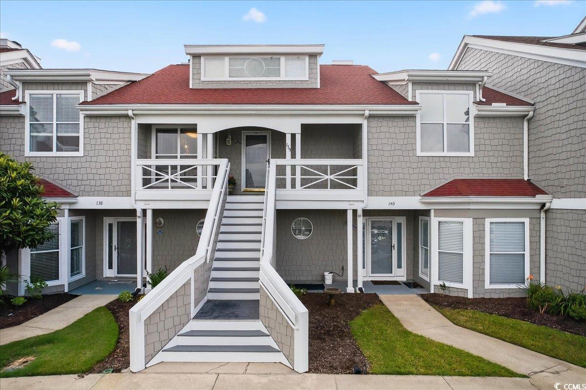 Image 1: View of front facade featuring stairs, a shingled