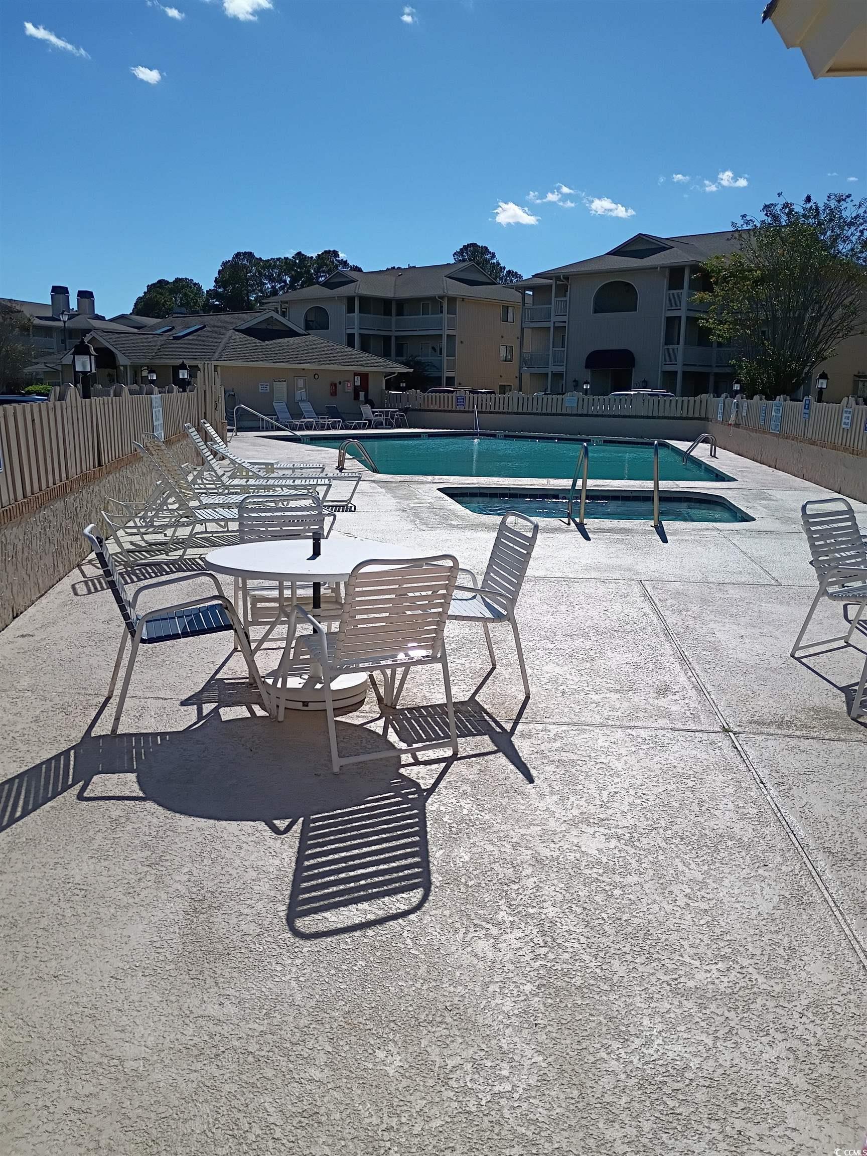Image 3: Community pool with a patio