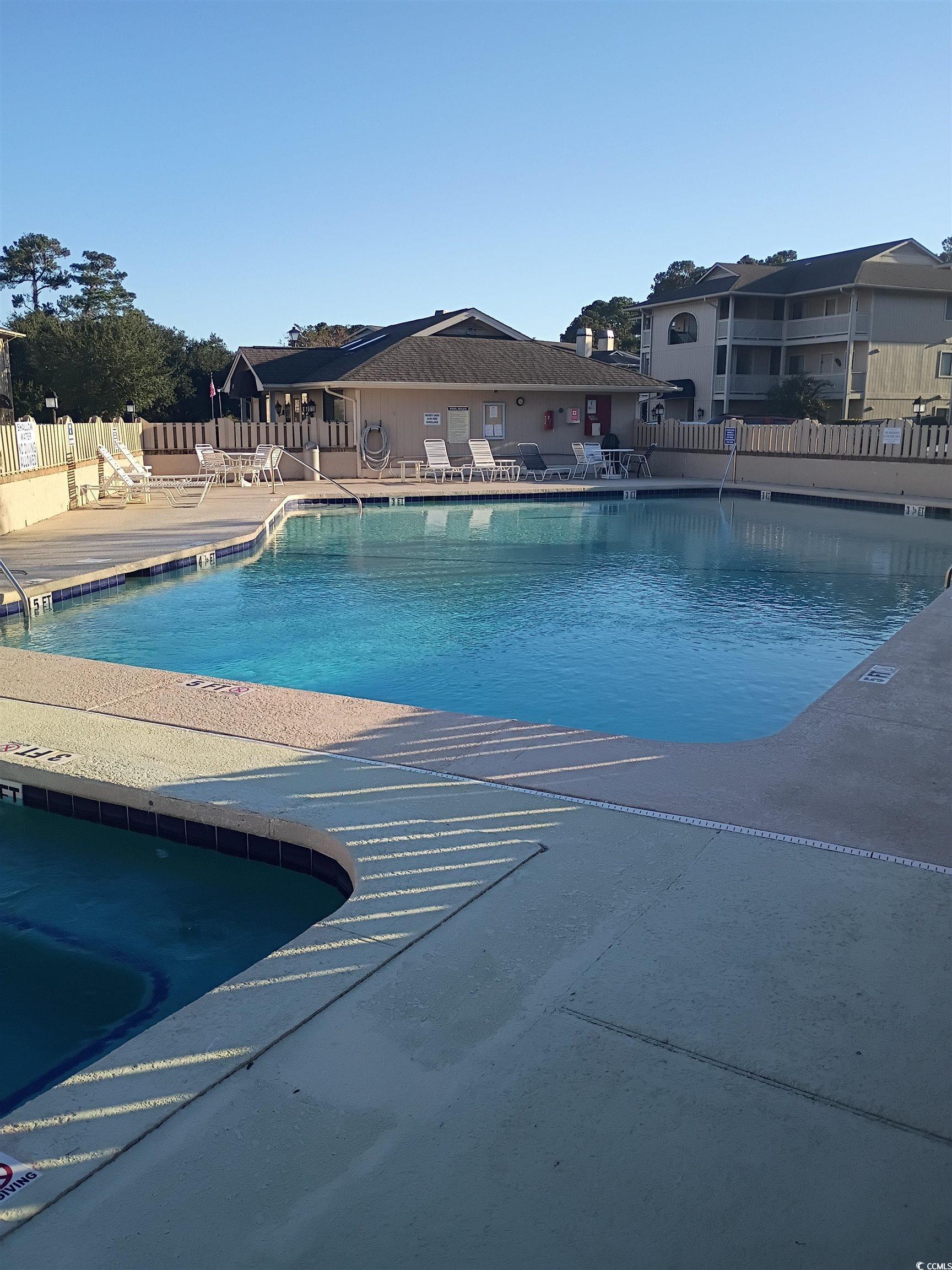 Image 4: Community pool with a patio