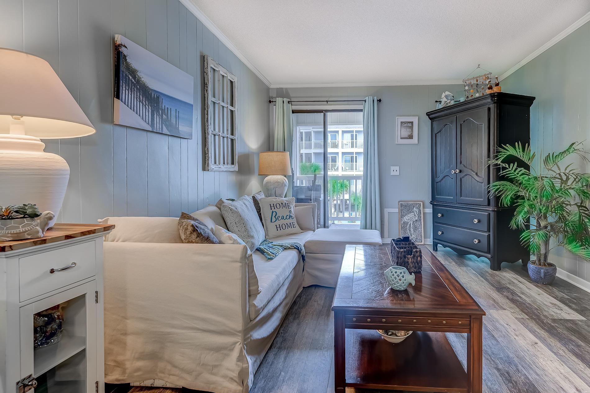 Image 3: Living area with crown molding, dark wood-style fl