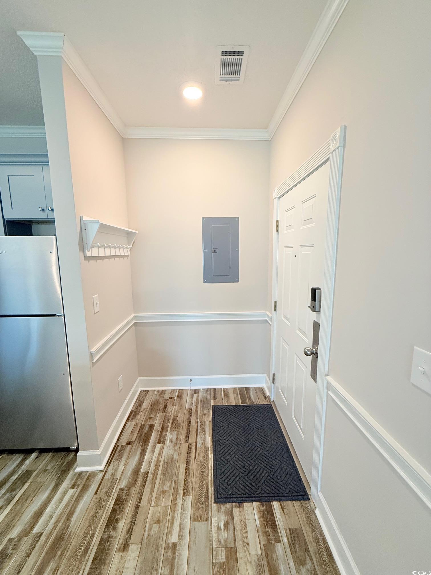 Image 2: Doorway to outside featuring crown molding, wood f