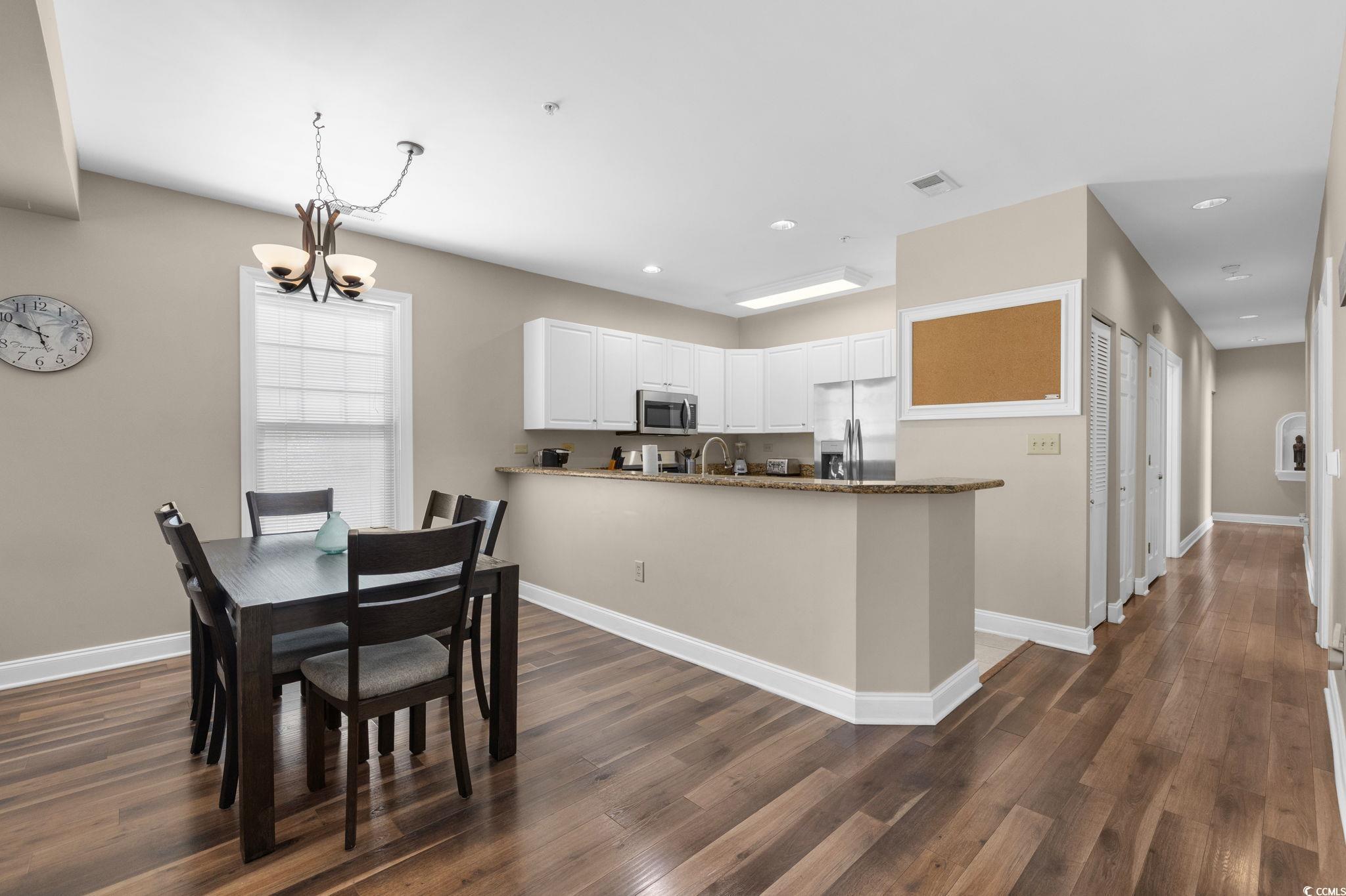 Image 2: Dining area featuring dark wood-style flooring, a Image 2: Dining area featuring dark wood-style flooring, a