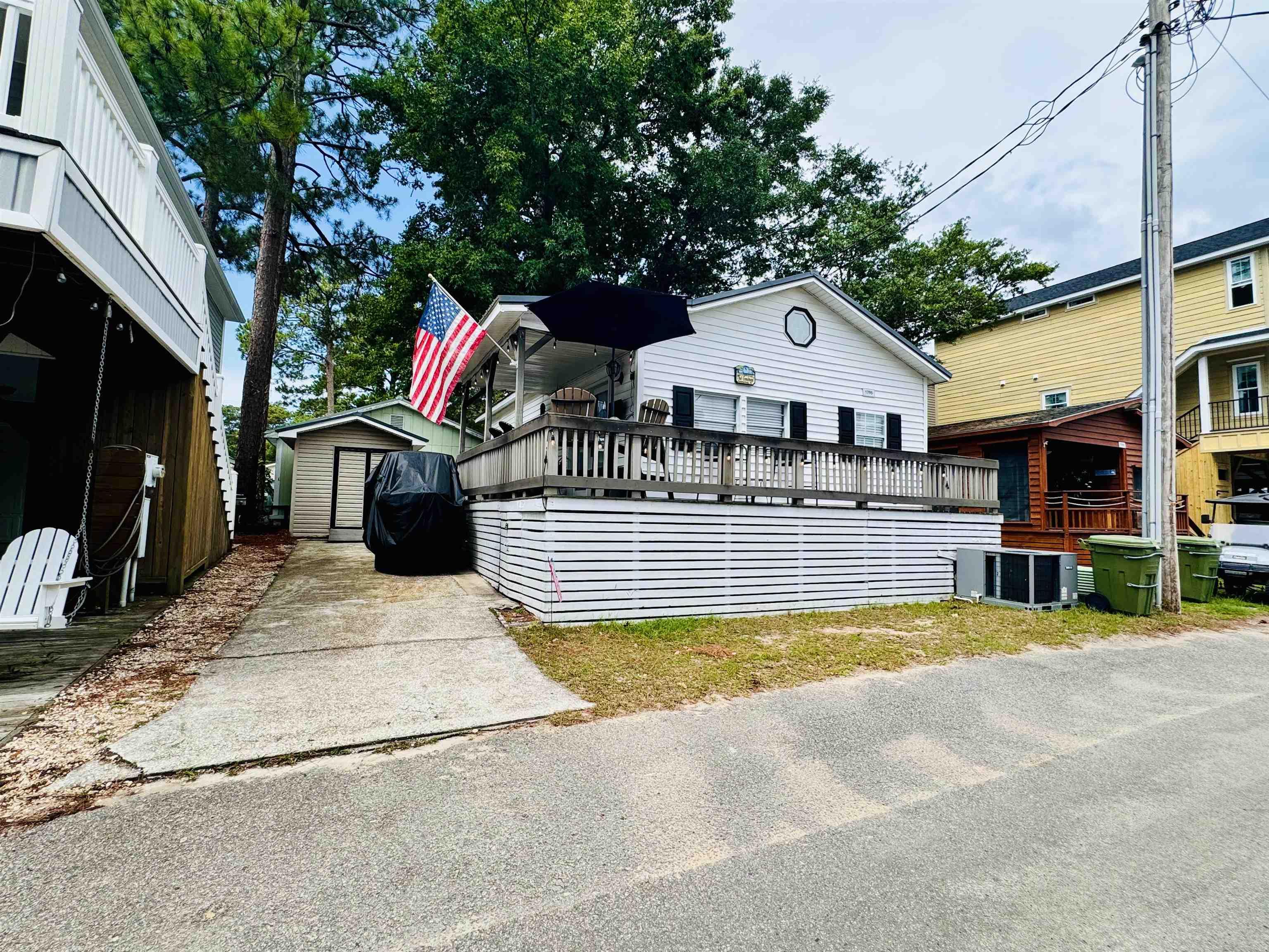Image 2: View of front facade featuring a wooden deck and a