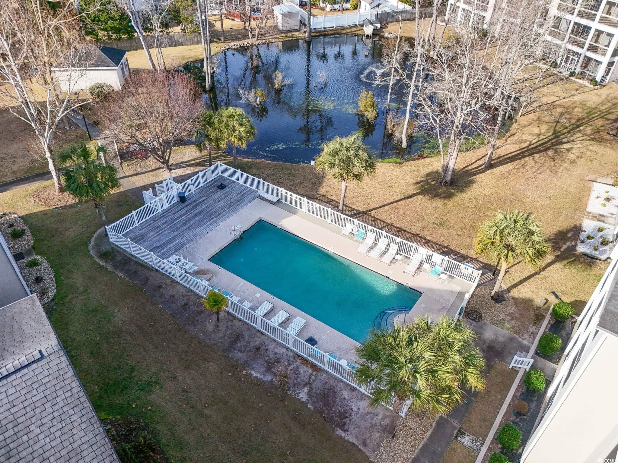 Image 3: Aerial view of a pool area and a nearby body of wa