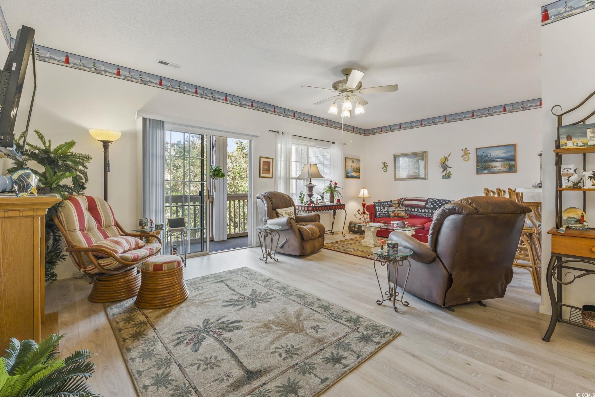 Image 4: Living room featuring a ceiling fan and light wood