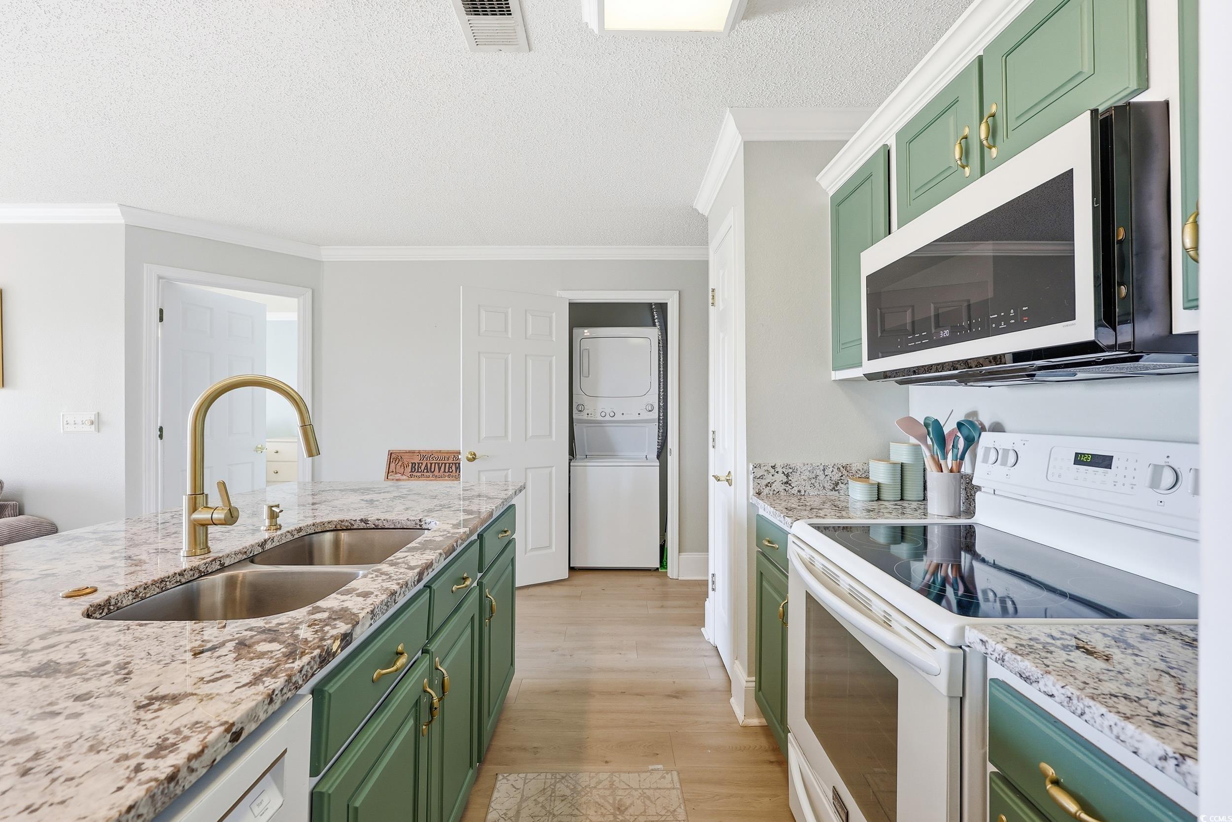 Image 2: Kitchen featuring green cabinetry, white range wit