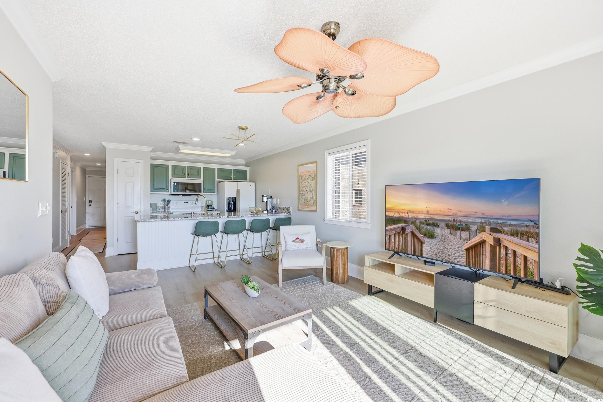 Image 3: Living area featuring crown molding, light wood-st