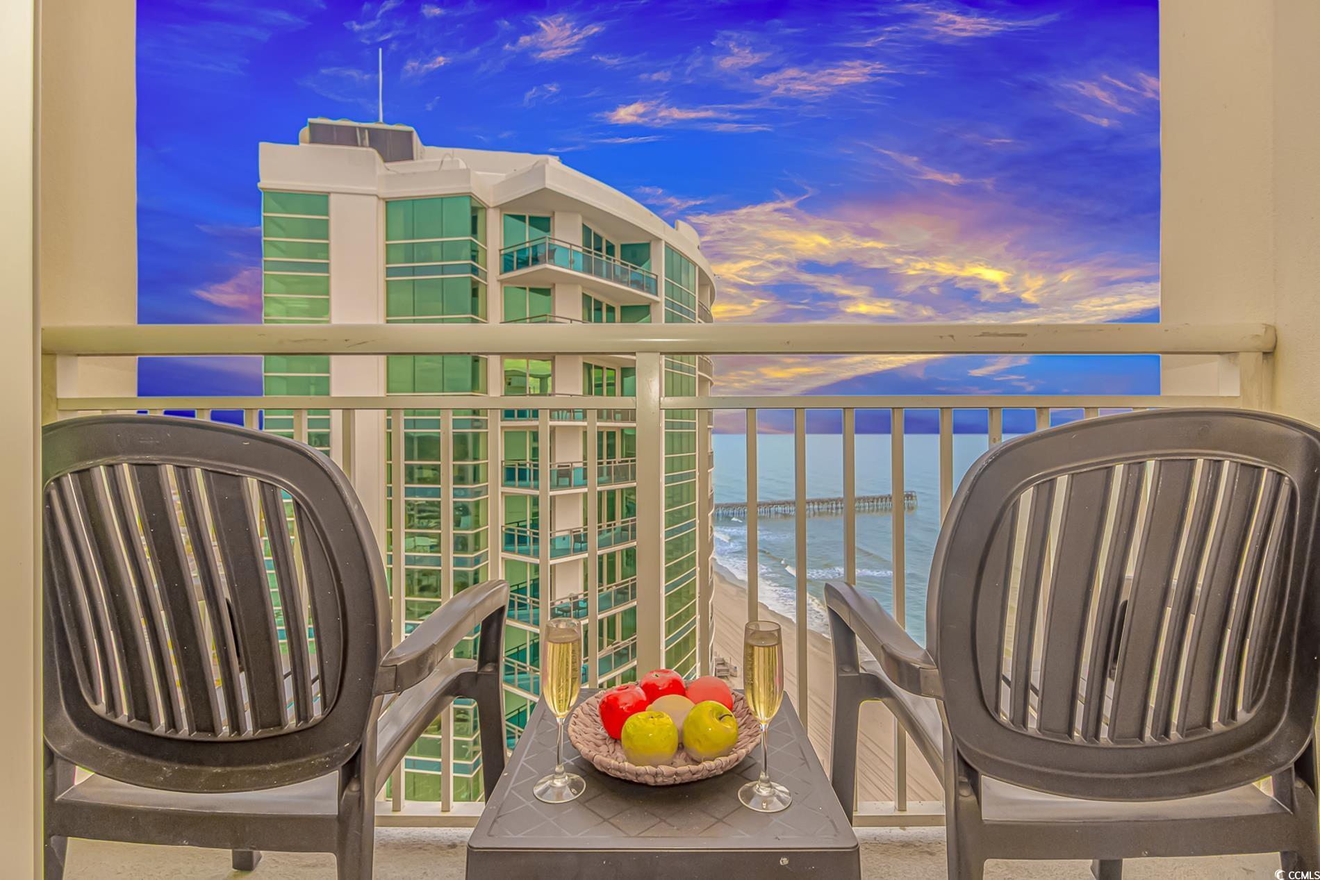 Image 2: Balcony at dusk featuring a water view