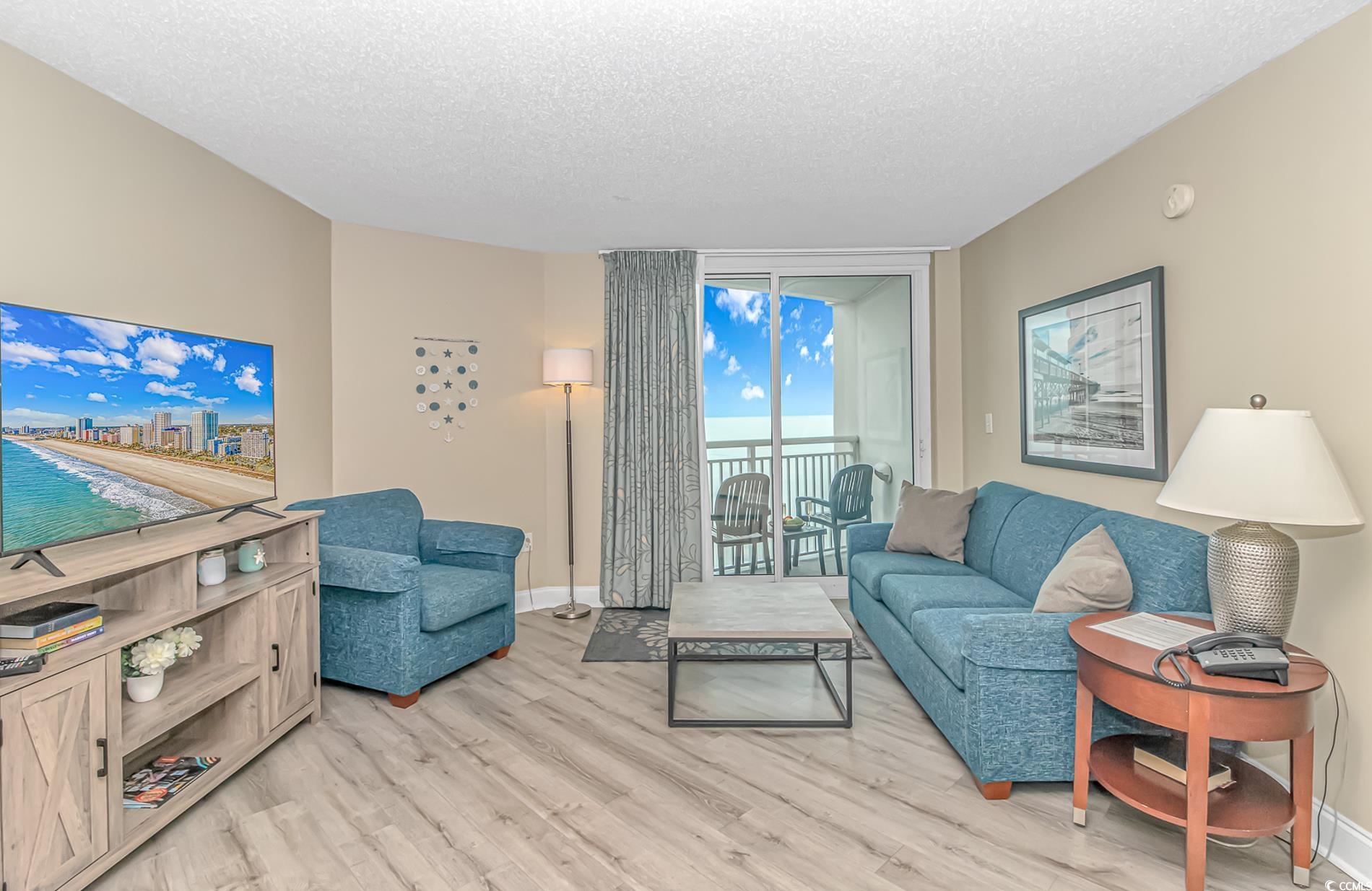 Image 3: Living room with floor to ceiling windows, a textu