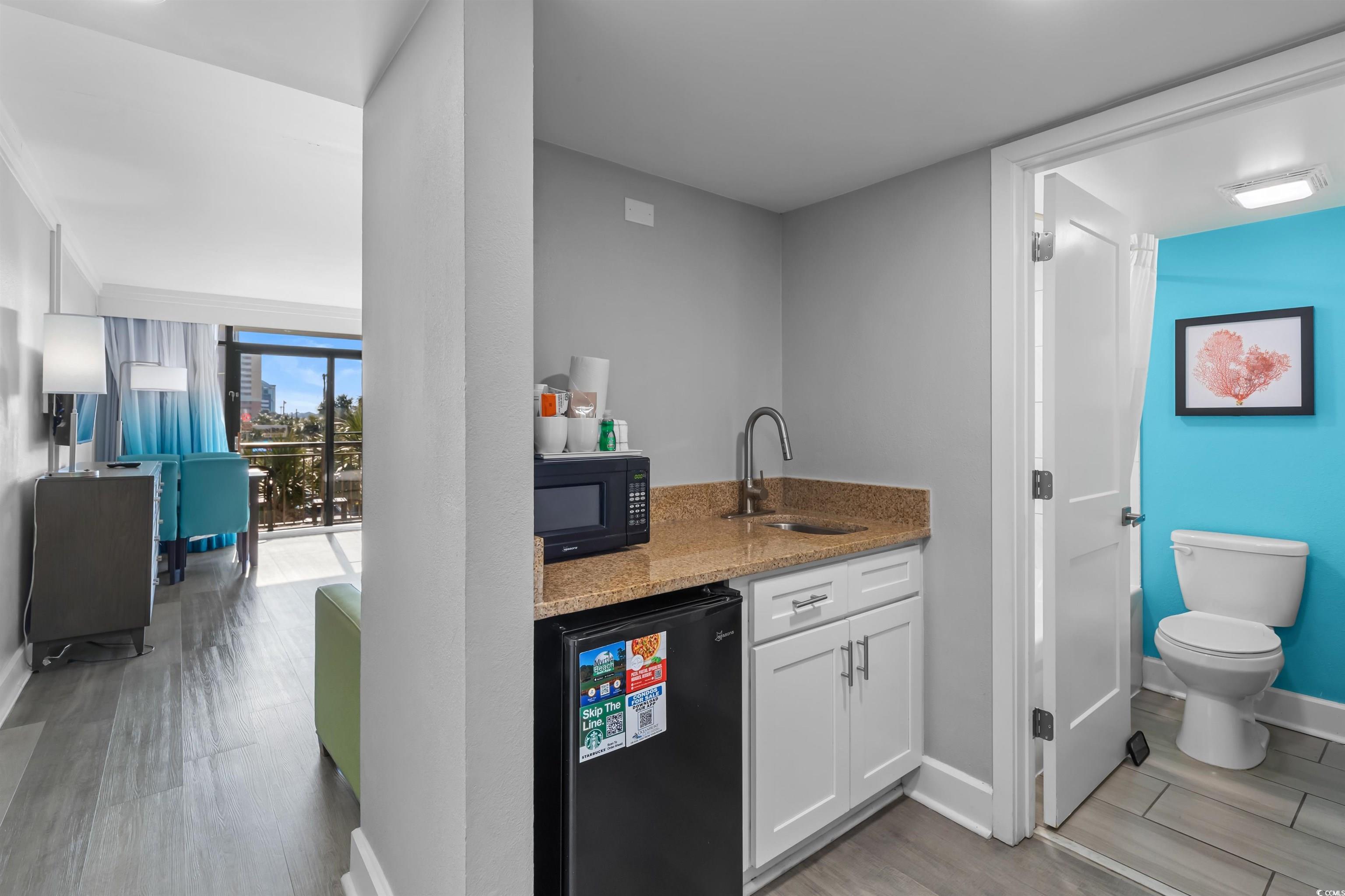 Image 2: Kitchen with baseboards, light stone counters, bla