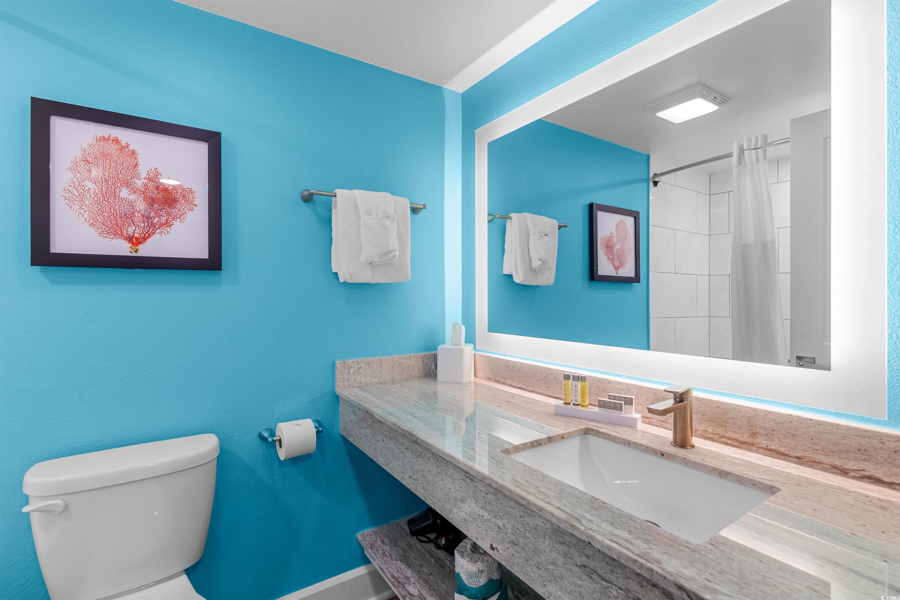 Image 4: Bathroom featuring curtained shower, vanity, and t