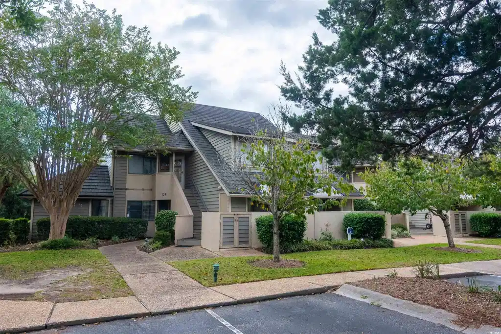 Image 1: View of front of home with stucco siding and uncov