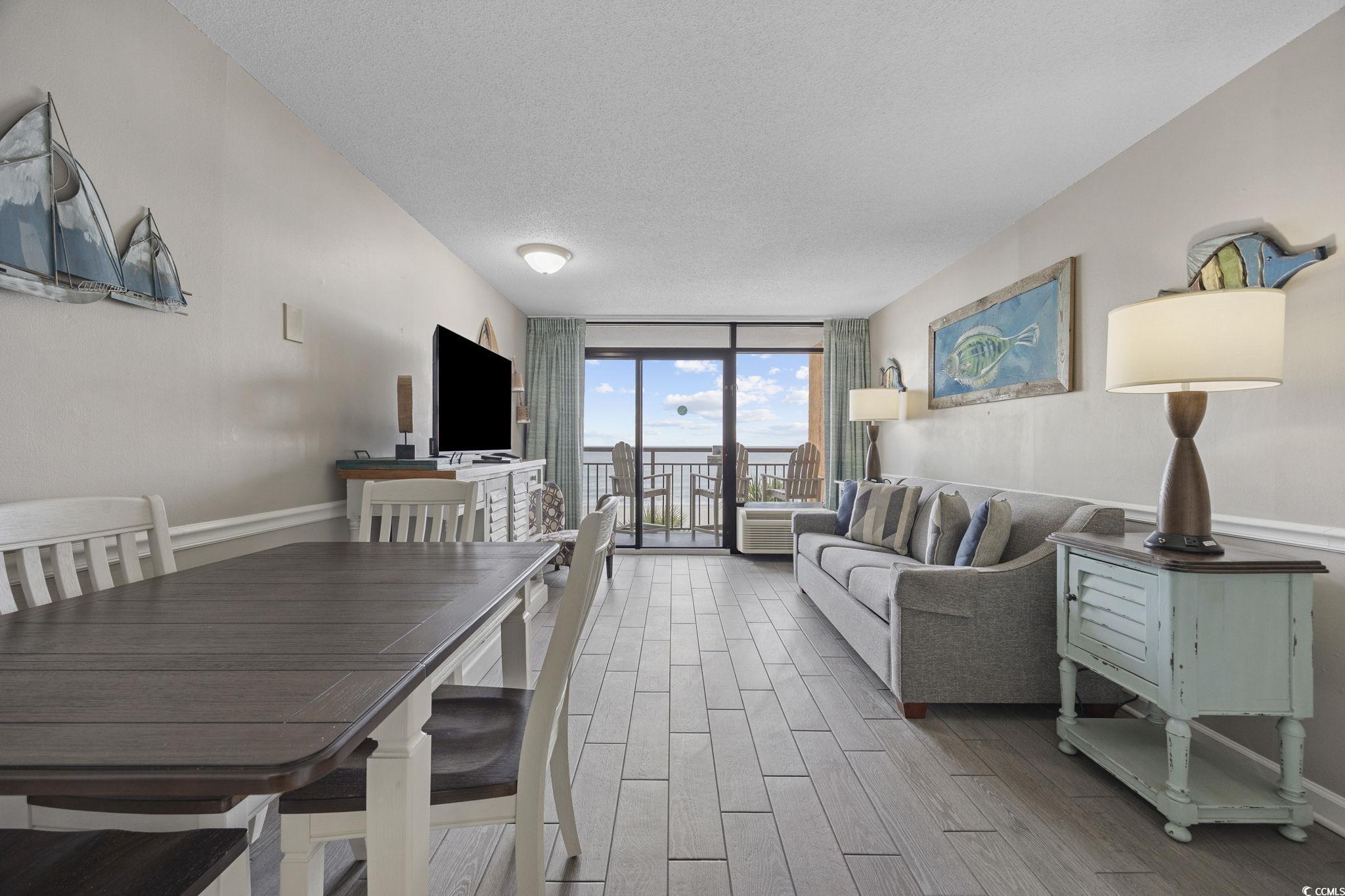 Image 3: Dining space featuring a wall of windows, a textur Image 3: Dining space featuring a wall of windows, a textur