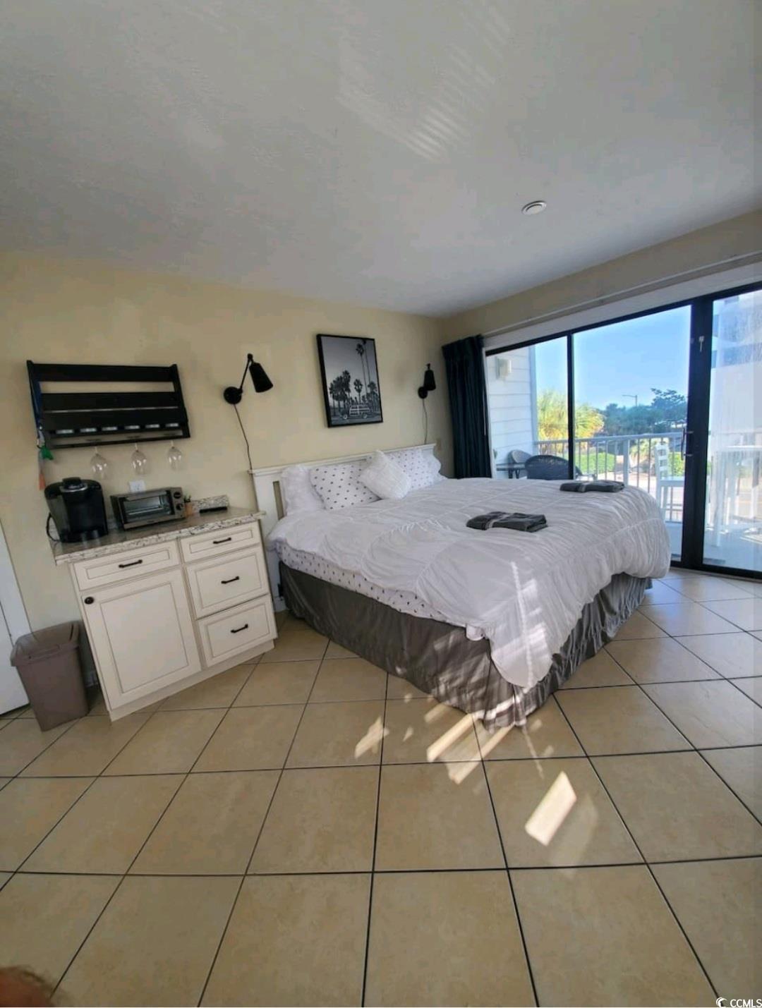 Image 2: Bedroom with light tile patterned floors and acces Image 2: Bedroom with light tile patterned floors and acces