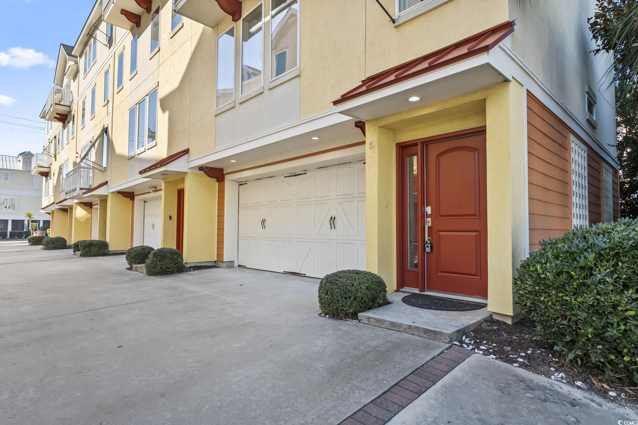 Image 2: Property entrance with stucco siding, an attached