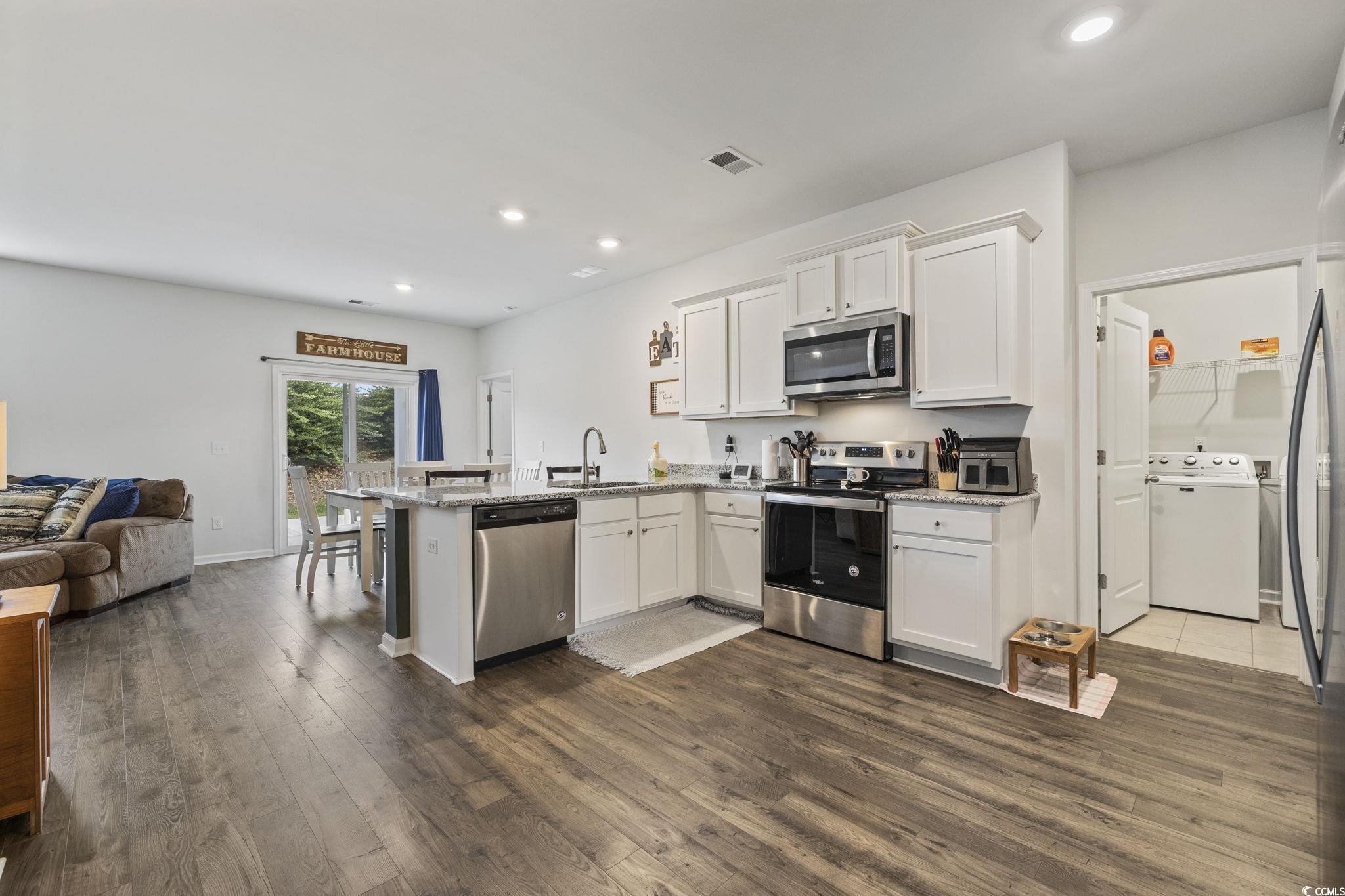 Image 4: Kitchen with a peninsula, white cabinetry, applian Image 4: Kitchen with a peninsula, white cabinetry, applian