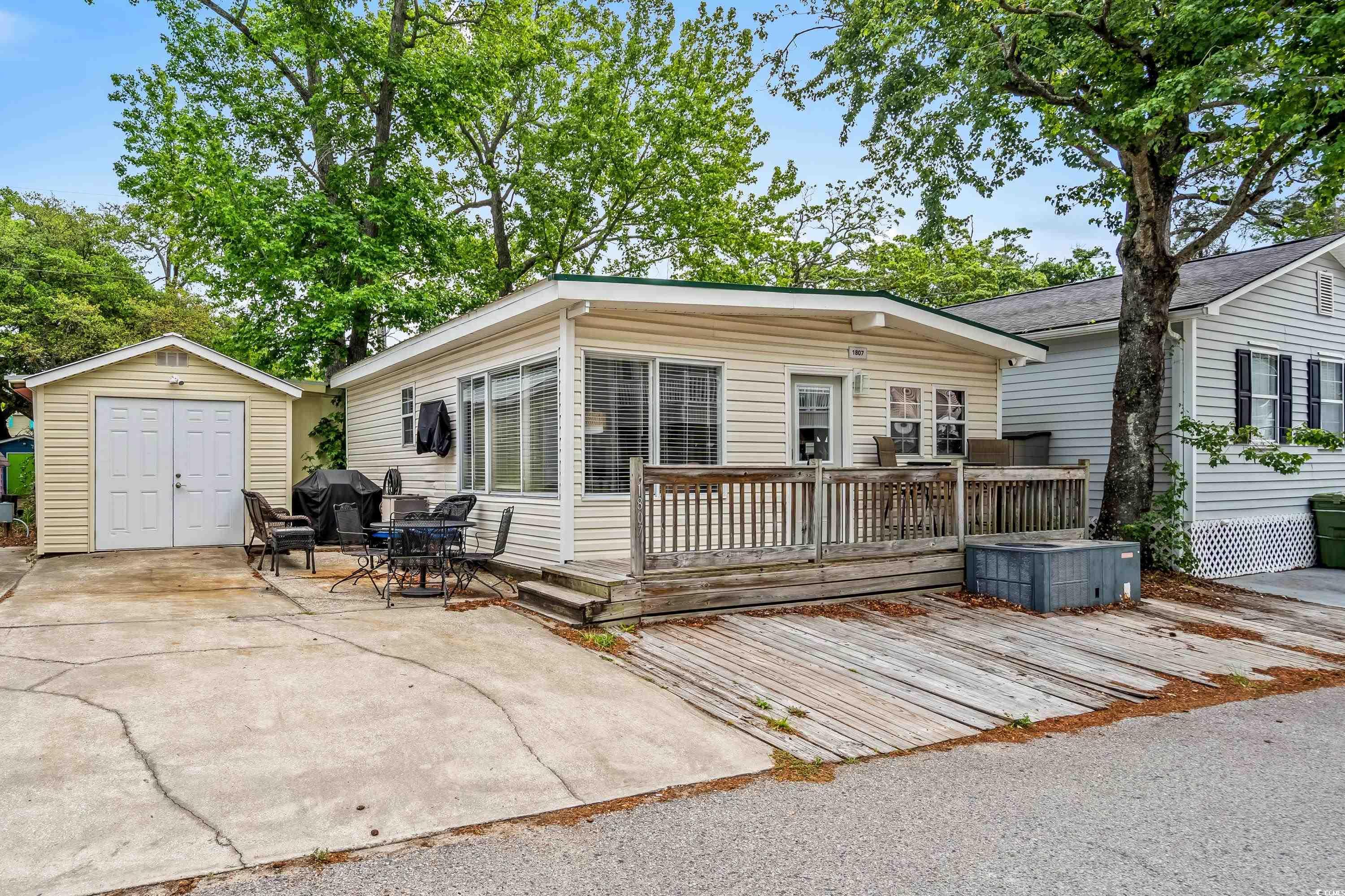 Image 3: Back of house with a wooden deck, a patio area, an Image 3: Back of house with a wooden deck, a patio area, an