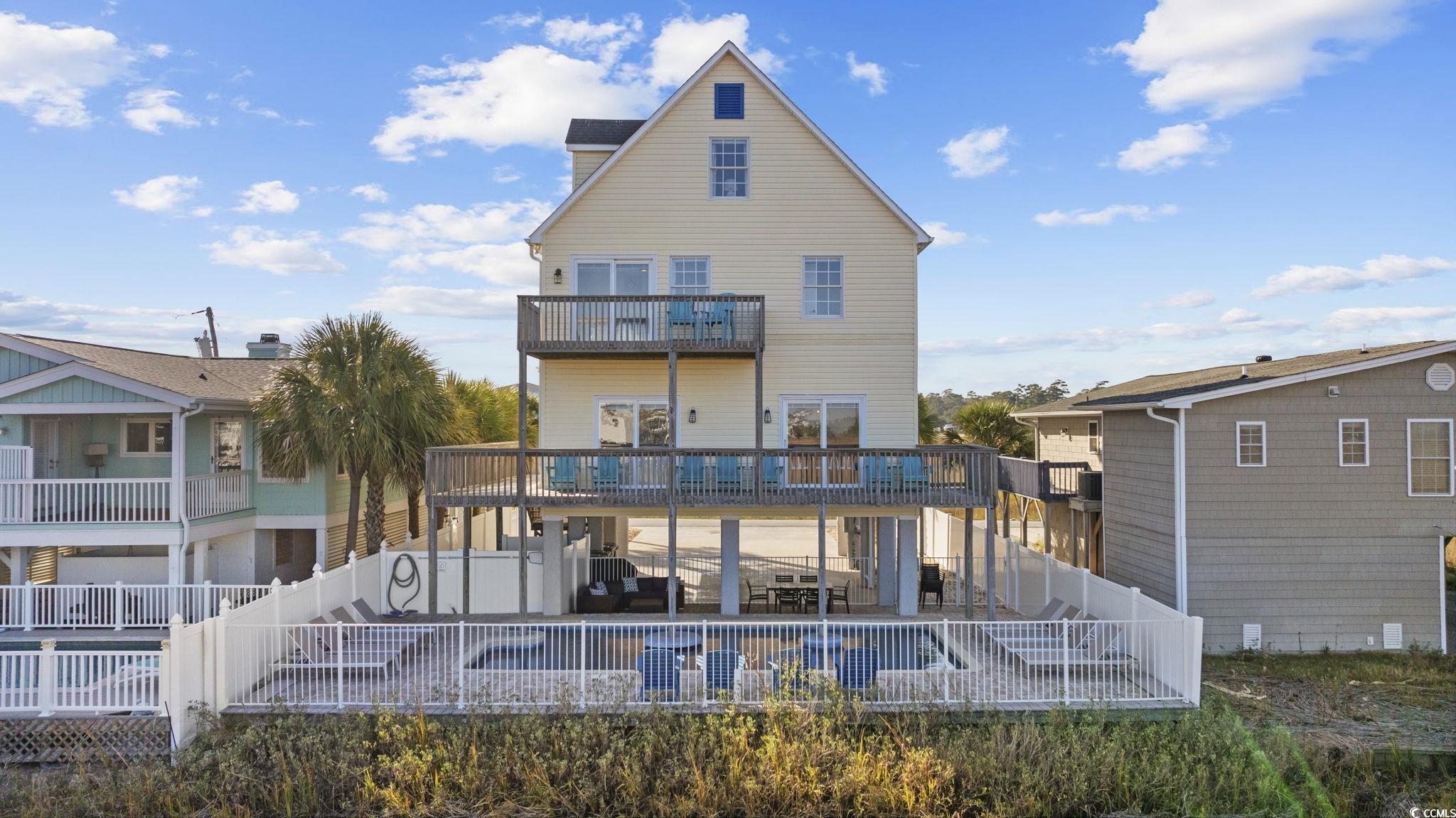 Image 2: Rear view of house with a fenced backyard, stairwa